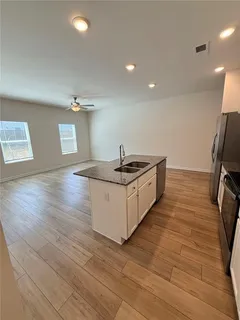 a kitchen with stainless steel appliances granite countertop a sink and a hard wood floor