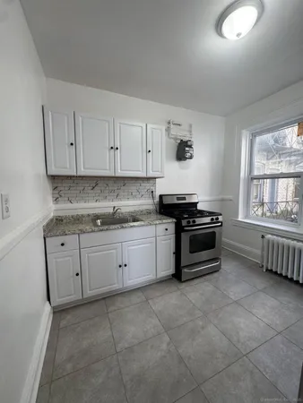 a kitchen with granite countertop a stove a sink and dishwasher