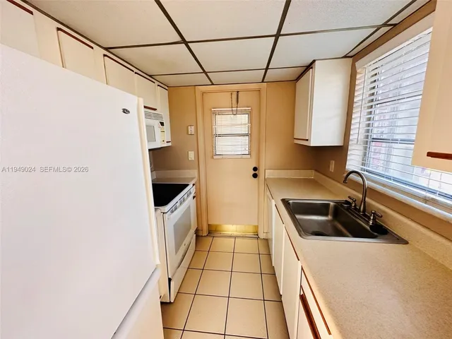 a kitchen with a sink a counter top space and cabinets