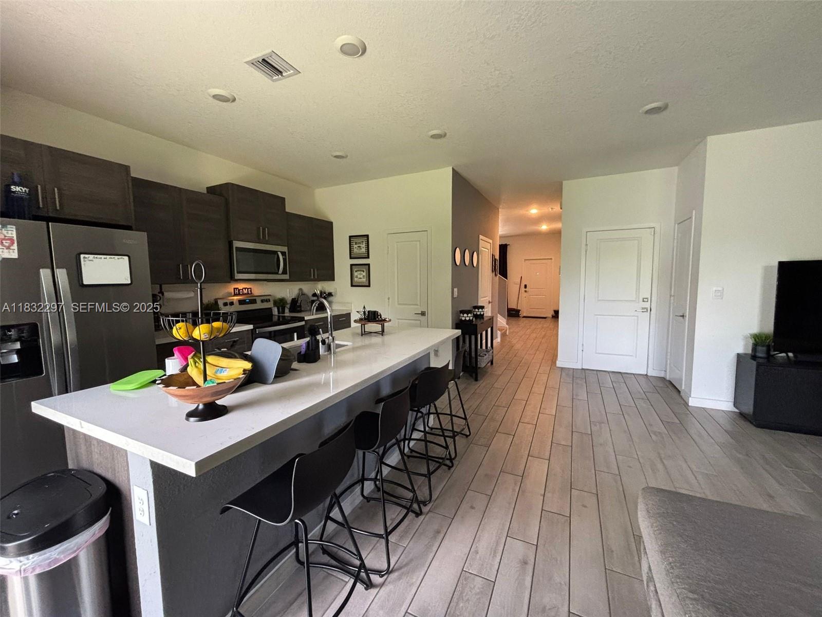 830 Southeast 19th Street Homestead, FL 33034 - Photo 4 of 16 a view of a dining room kitchen with furniture and wooden floor