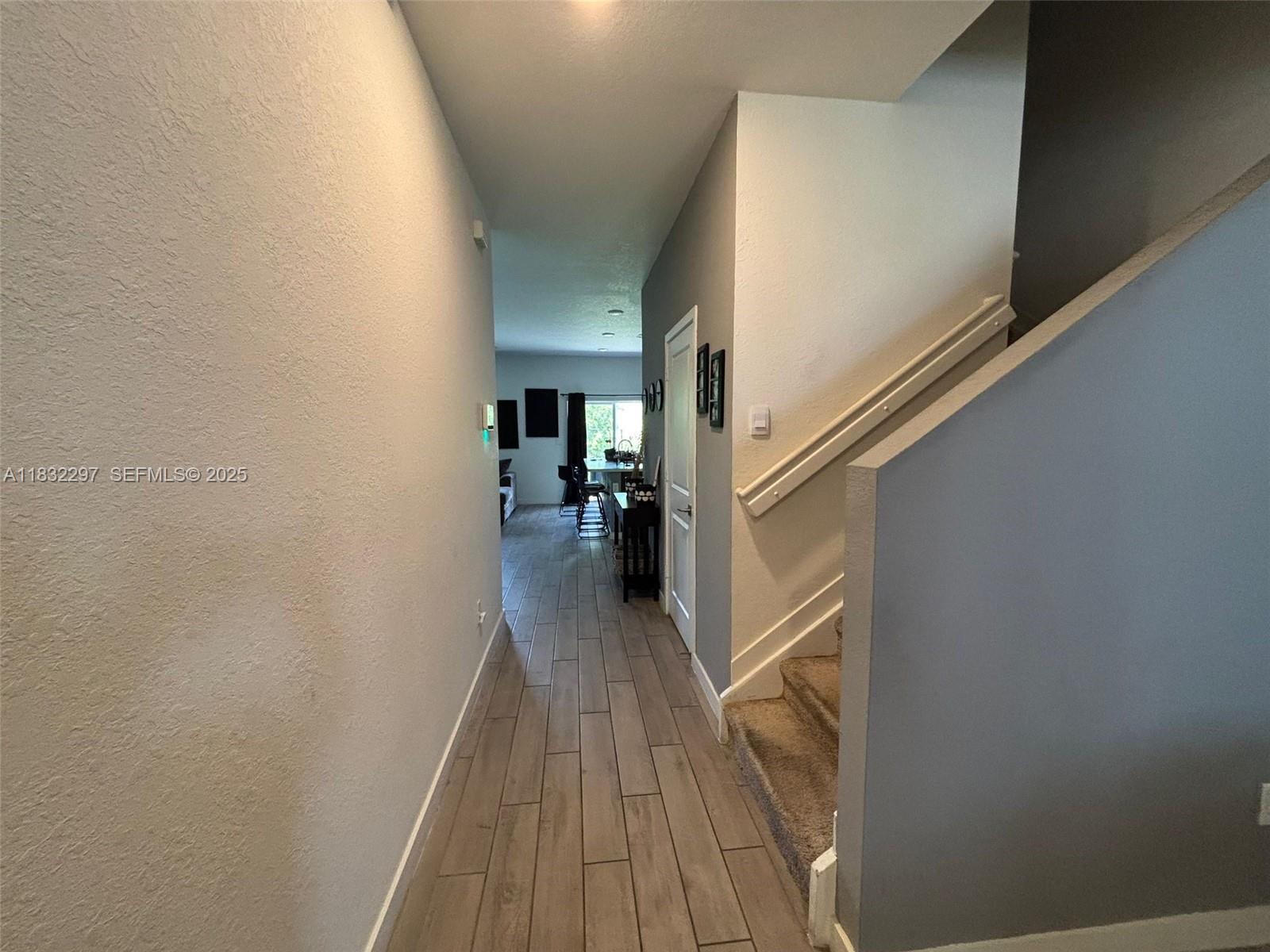 830 Southeast 19th Street Homestead, FL 33034 - Photo 5 of 16 a view of hallway with stairs and wooden floor