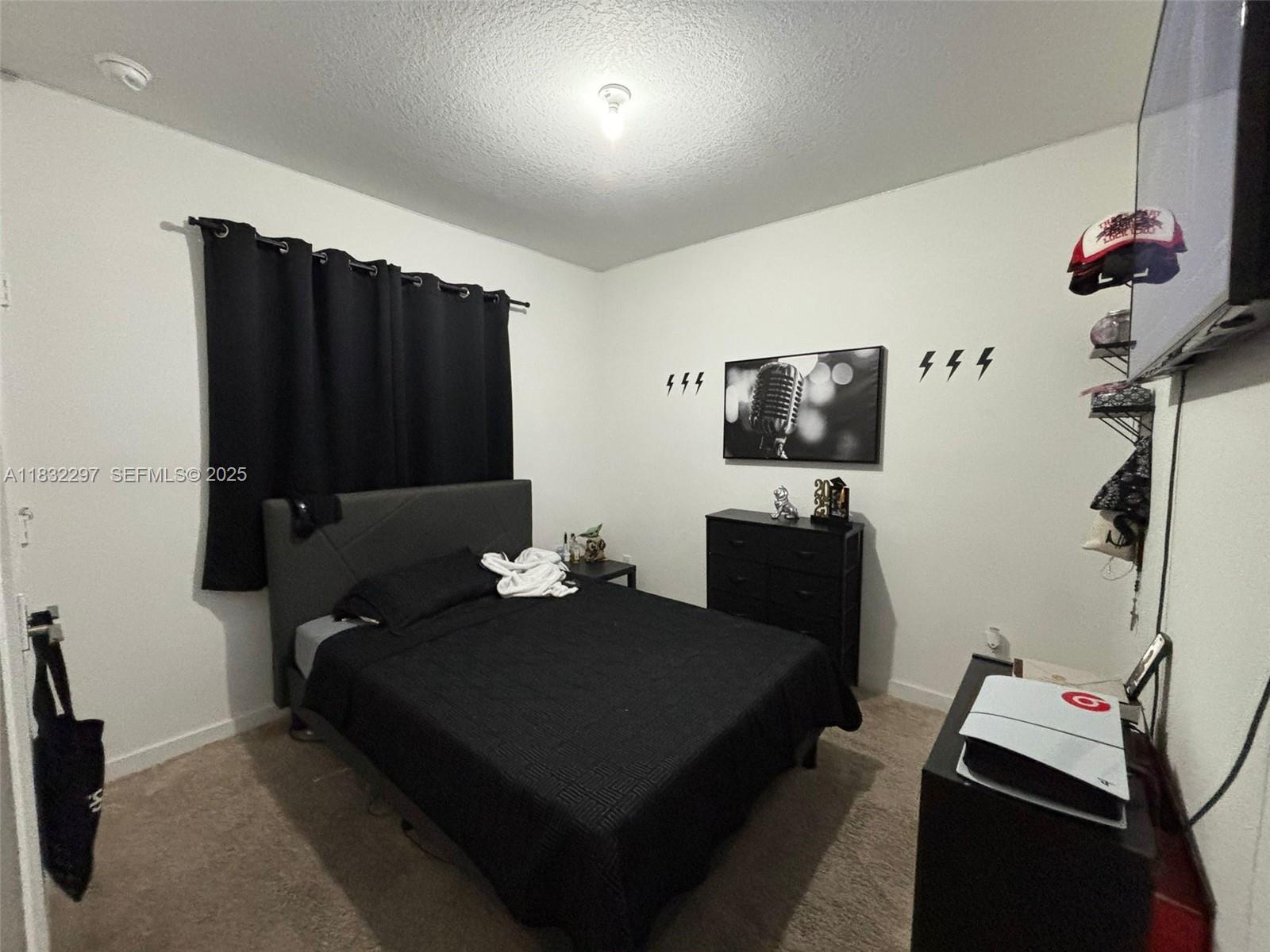 830 Southeast 19th Street Homestead, FL 33034 - Photo 10 of 16 a bedroom with a bed and a flat tv screen on wall