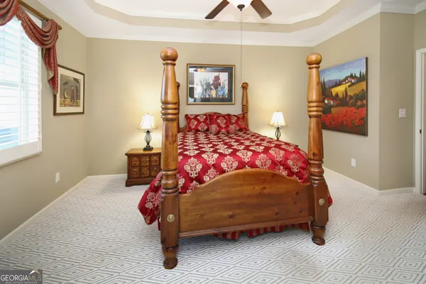 a bedroom with a bed and painting on the wall