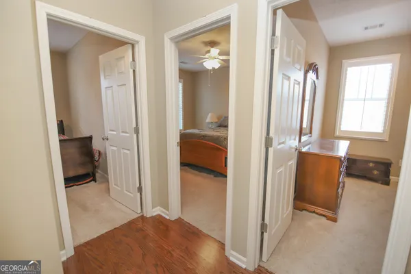 a view of hallway with bathroom and glass door