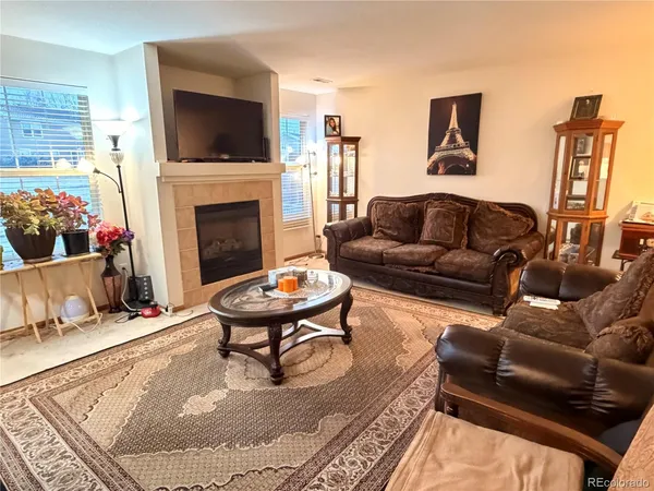a living room with furniture a flat screen tv and a fireplace