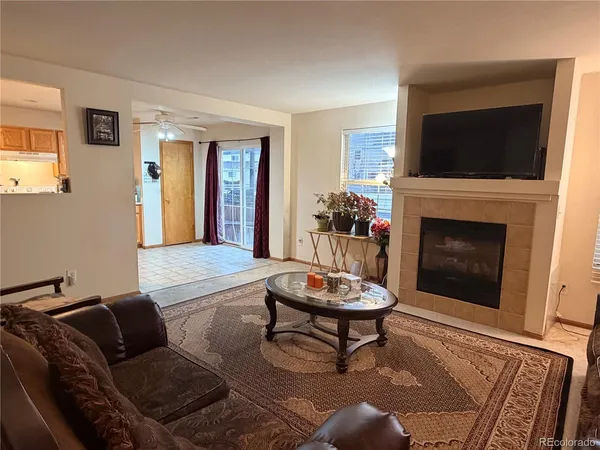 a living room with furniture a flat screen tv and a fireplace