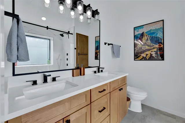 a bathroom with a toilet a sink and mirror