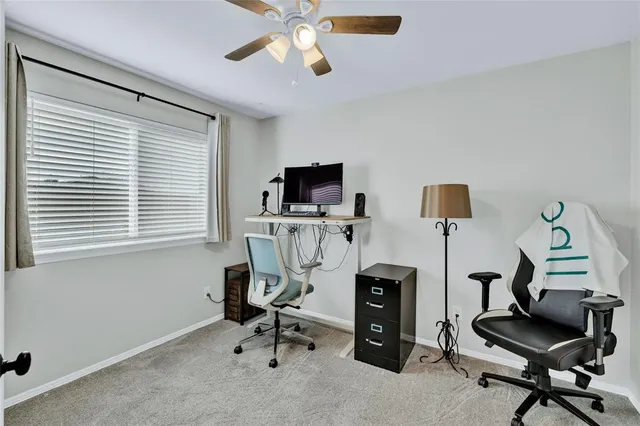 a view of a workspace with furniture and a window