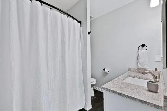 a bathroom with a granite countertop sink and mirror