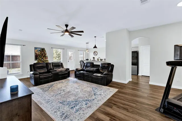 a living room with furniture and a wooden floor