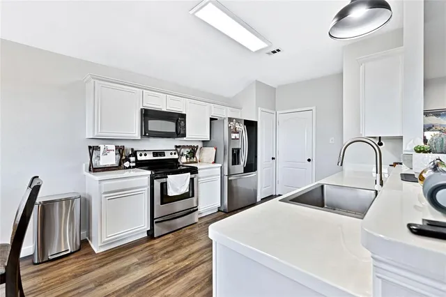a kitchen with white cabinets and stainless steel appliances