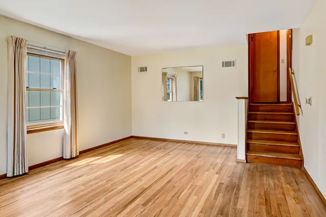a view of a room with wooden floor and windows