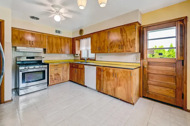 a kitchen with stainless steel appliances granite countertop a refrigerator a stove and cabinets