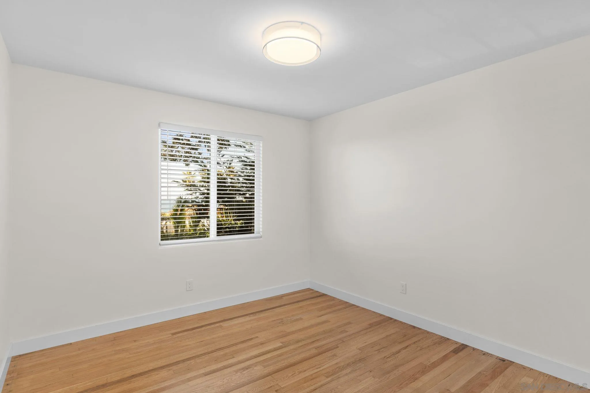 725 Coast S Boulevard La Jolla, CA 92037 - Photo 19 of 23 an empty room with wooden floor and windows