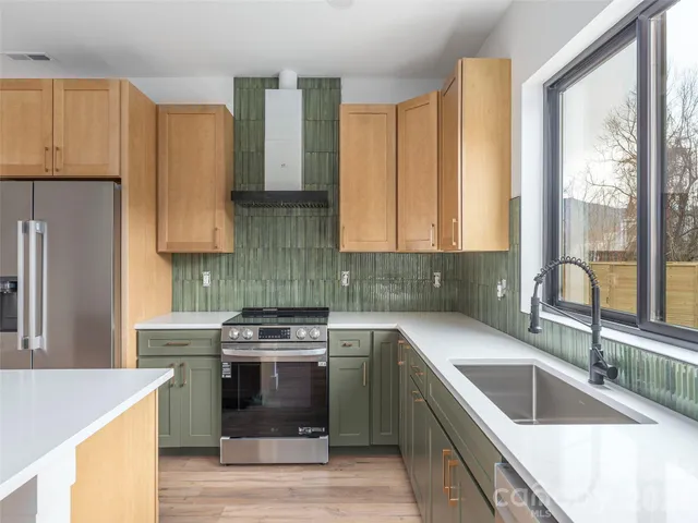 a kitchen with stainless steel appliances granite countertop a sink stove and refrigerator
