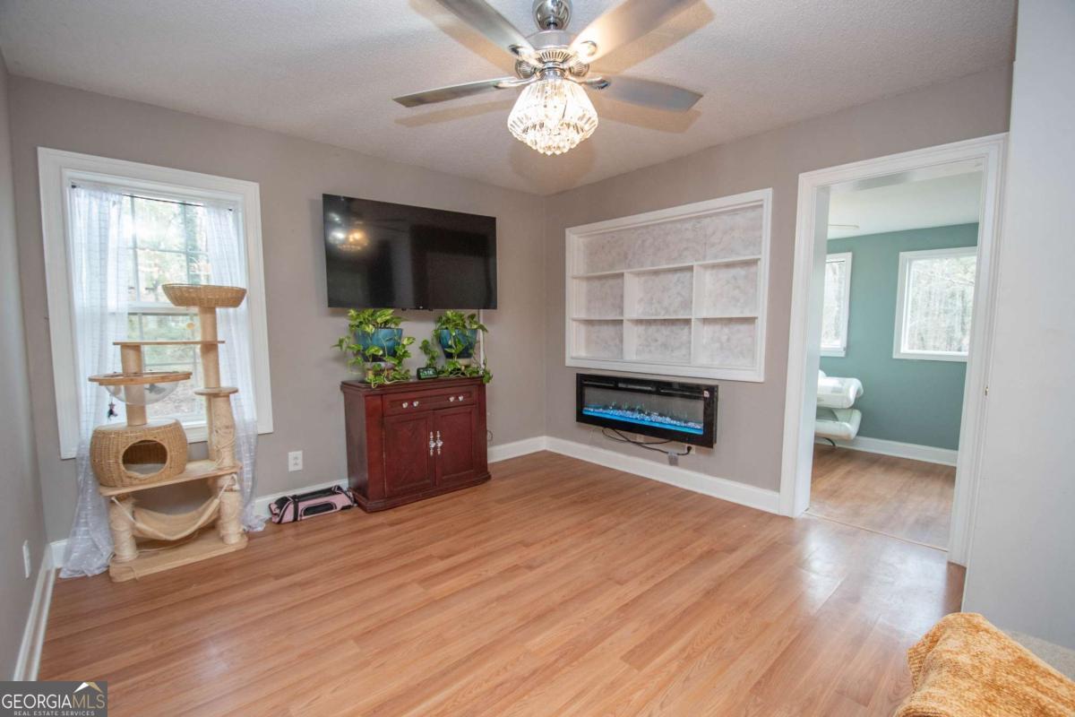 134 Rustica Drive Newnan, GA 30263 - Photo 7 of 32 a living room with wooden floor and a ceiling fan