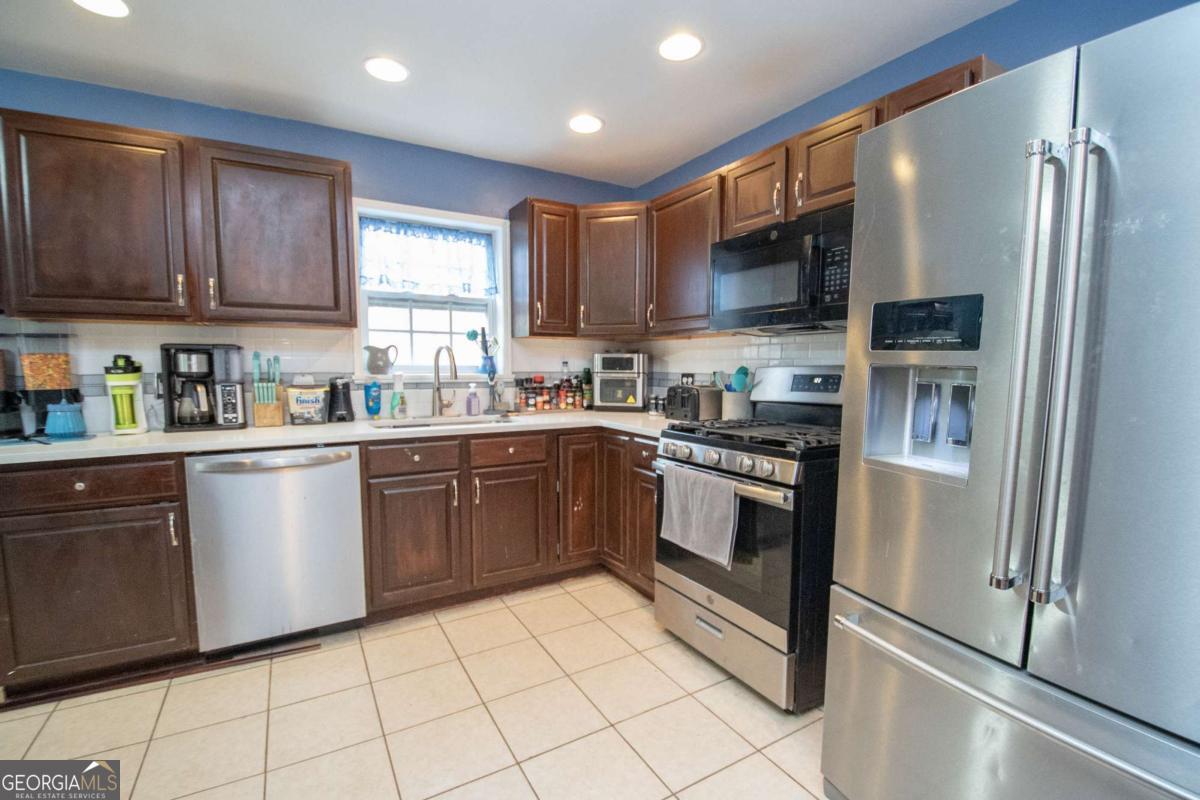 134 Rustica Drive Newnan, GA 30263 - Photo 8 of 32 a kitchen with stainless steel appliances granite countertop a refrigerator sink and cabinets