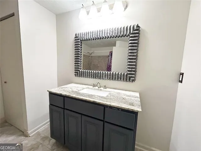 a bathroom with a granite countertop sink and vanity