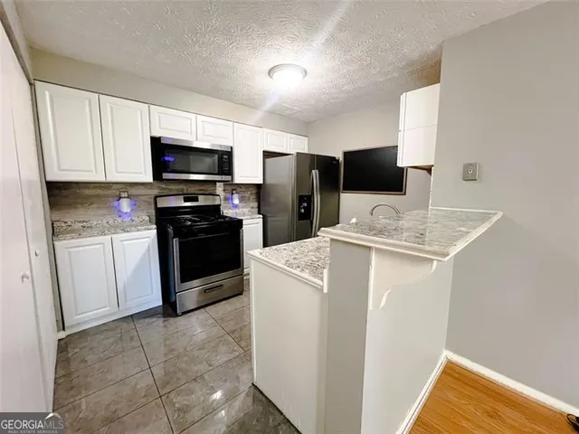 a kitchen with a sink a microwave a refrigerator and cabinets