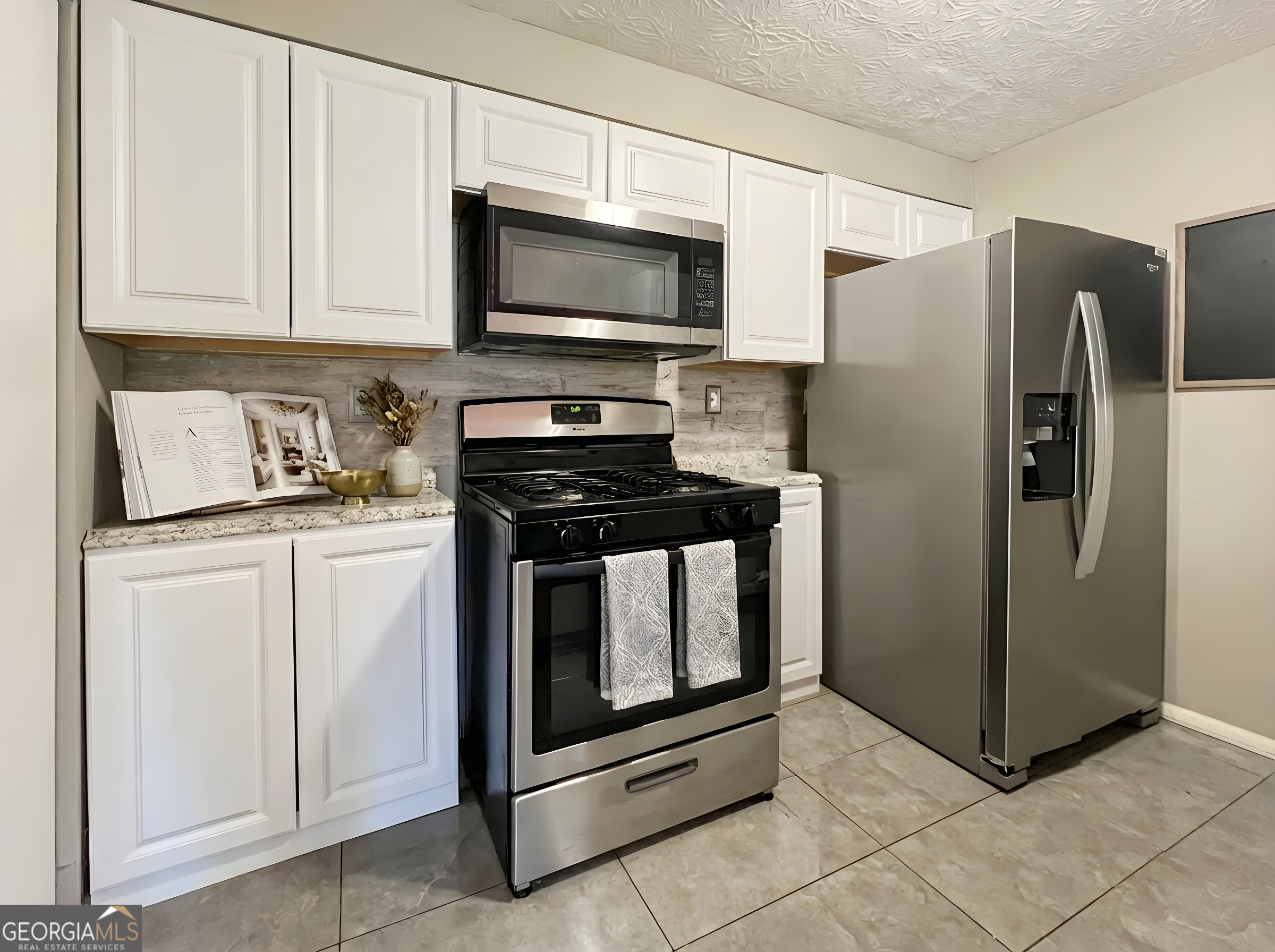 6379 Wedgeview Court Tucker, GA 30084 - Photo 5 of 16 a kitchen with white cabinets and stainless steel appliances
