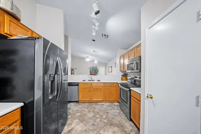 a kitchen with stainless steel appliances granite countertop a sink stove and refrigerator