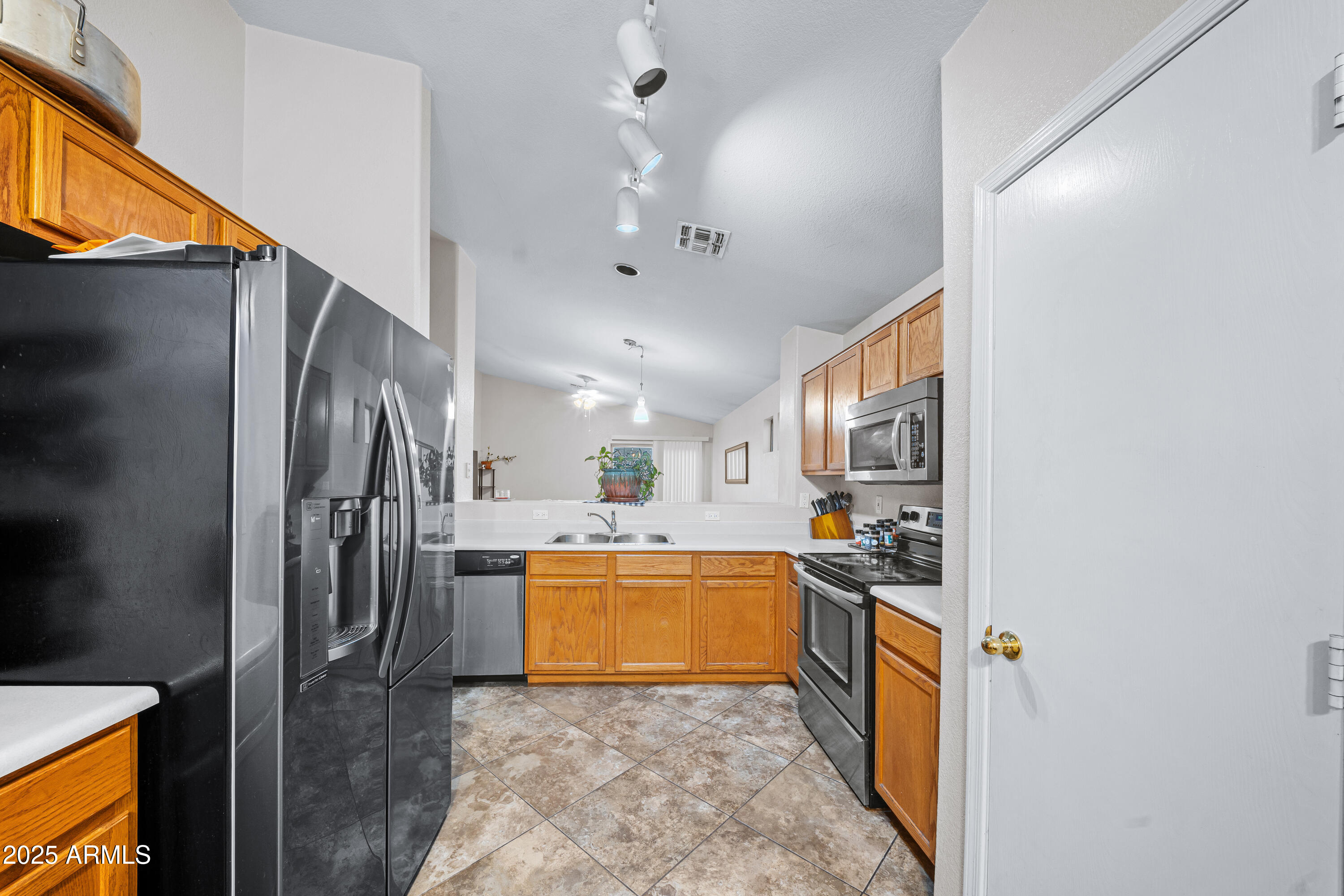 1428 West Mesquite Avenue Apache Junction, AZ 85120 - Photo 4 of 16 a kitchen with stainless steel appliances granite countertop a refrigerator and a sink