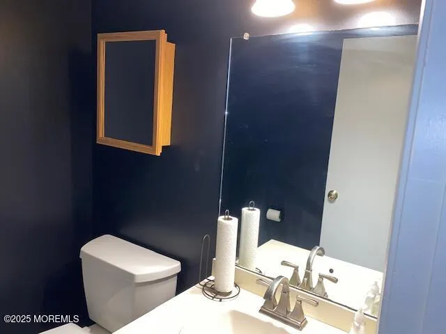 a bathroom with a toilet sink and mirror