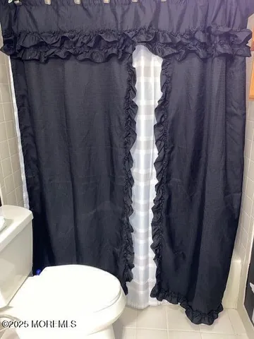 a bathroom with a toilet and a shower curtain