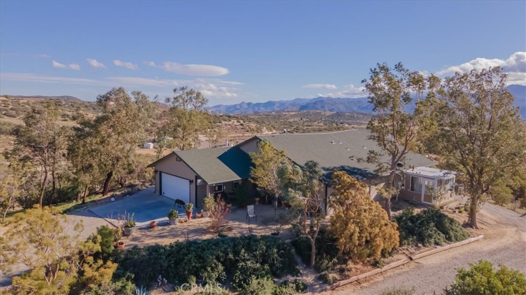 a view of a house with a yard and mountain view