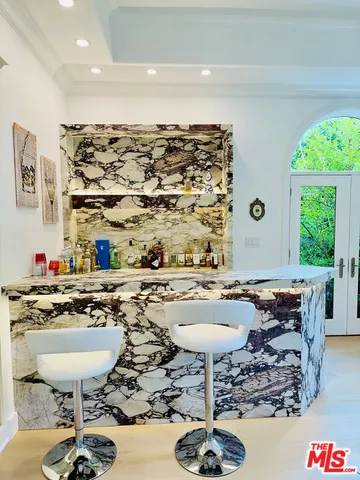 a living room with furniture chandelier and a large window