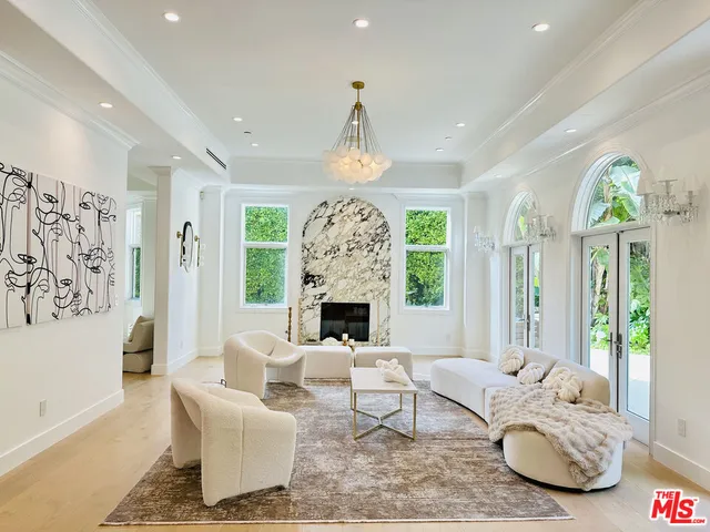 a living room with furniture a fireplace and a chandelier