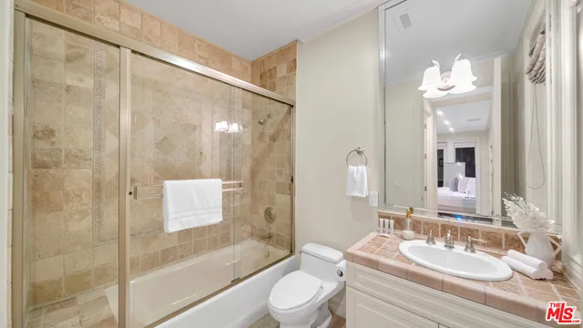 a bathroom with a bathtub shower sink vanity and toilet