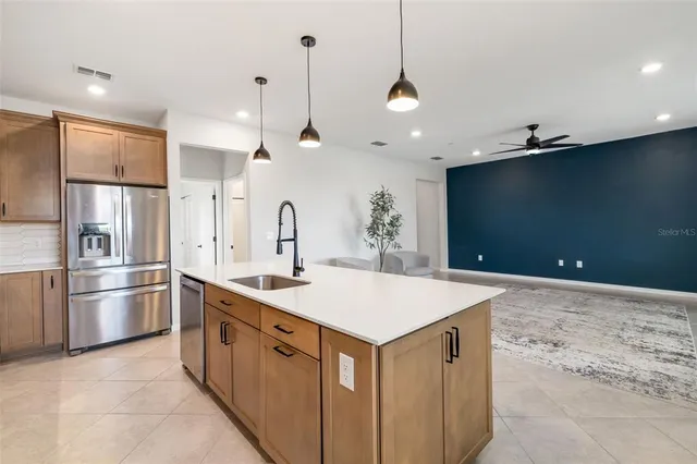 a kitchen with kitchen island a sink a stove and a refrigerator