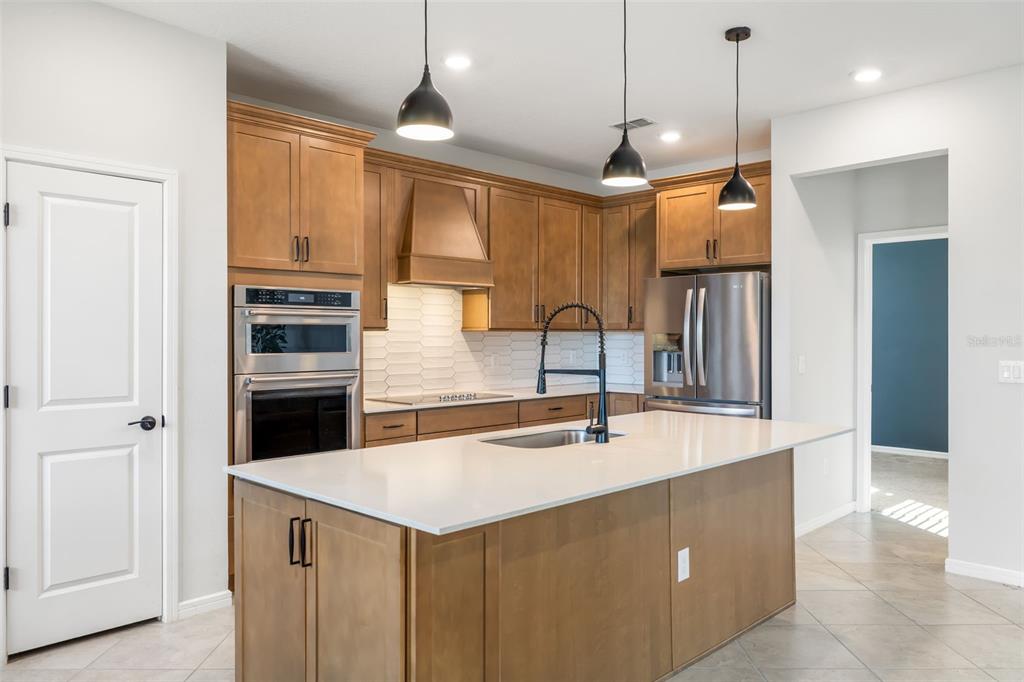 9406 Lamine Way Parrish, FL 34219 - Photo 9 of 74 a kitchen with kitchen island a sink a stove and a refrigerator