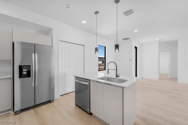 a kitchen with stainless steel appliances granite countertop a refrigerator a sink and a stove