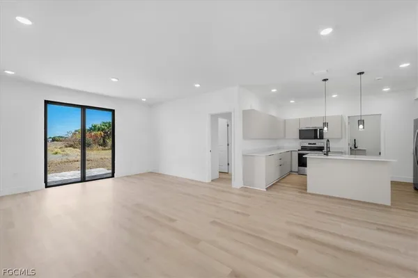 a view of kitchen with kitchen island white cabinets and stainless steel appliances