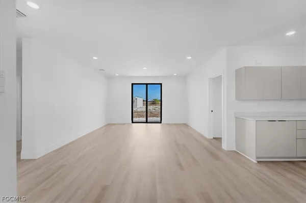 an empty room with wooden floor and sink