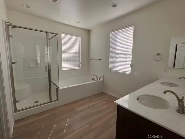 a bathroom with a granite countertop sink two mirror and shower