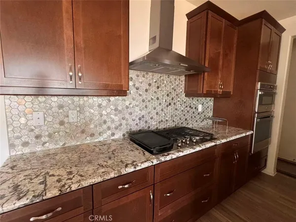 a kitchen with granite countertop a sink and cabinets