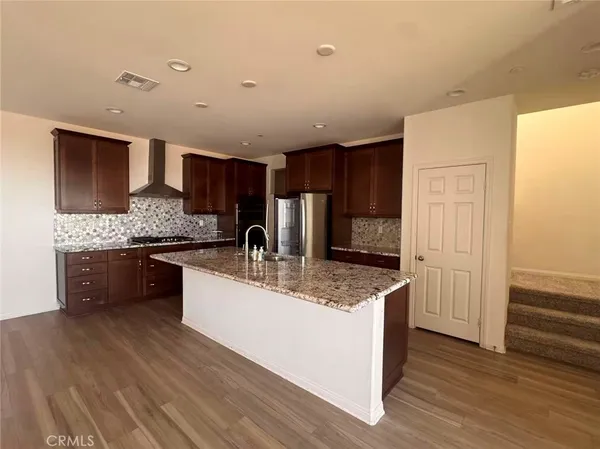 a kitchen with stainless steel appliances granite countertop a sink refrigerator and cabinets