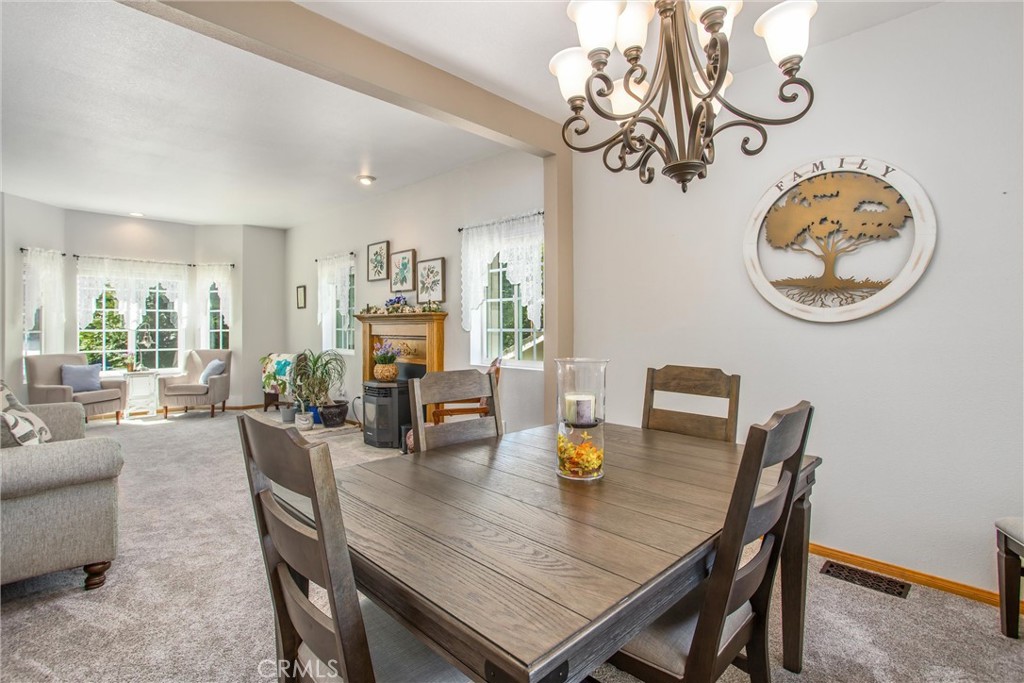 6180 Cedar Avenue Angelus Oaks, CA 92305 - Photo 8 of 31 a view of a dining room with furniture a chandelier and wooden floor