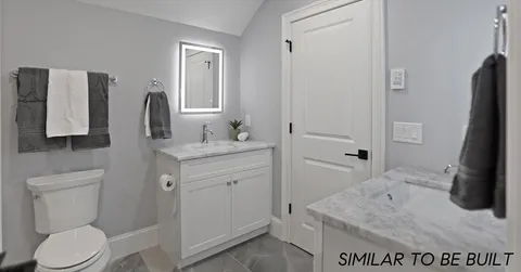 a bathroom with a sink toilet and mirror