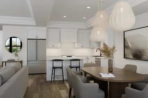 a kitchen with stainless steel appliances kitchen island granite countertop a dining table chairs and a refrigerator