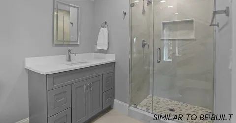 a bathroom with a sink vanity granite shower and a mirror