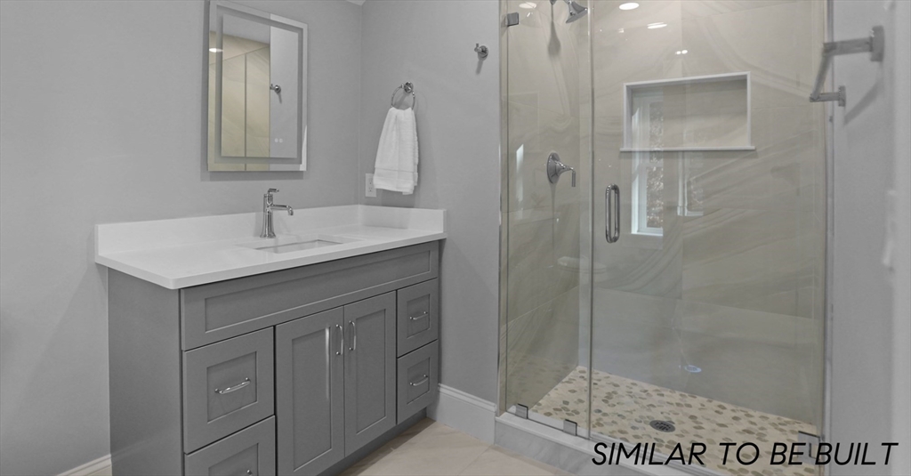 10 Webber Avenue, Unit 4D Bedford, MA 01730 - Photo 9 of 17 a bathroom with a sink vanity granite shower and a mirror