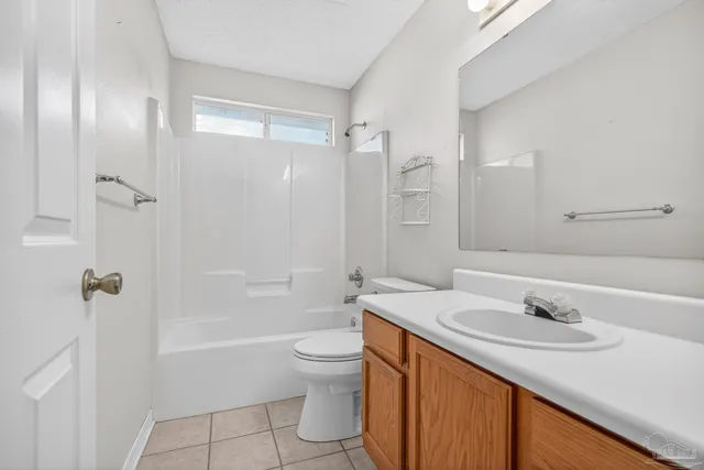 a view of a hallway with wooden floor and a bathroom