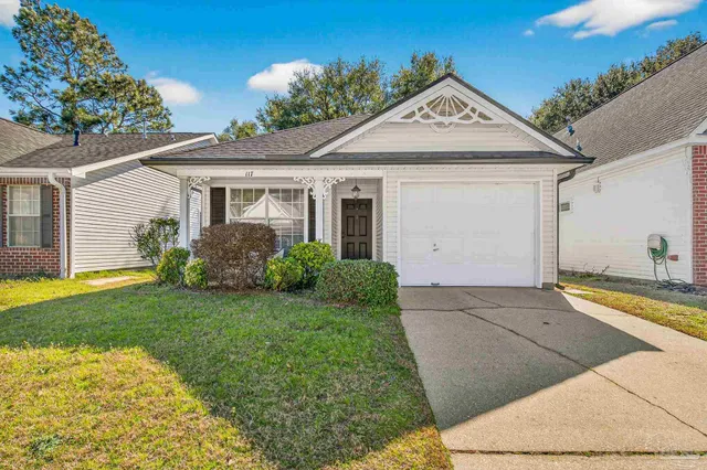 a view of a white house next to a yard and potted plants