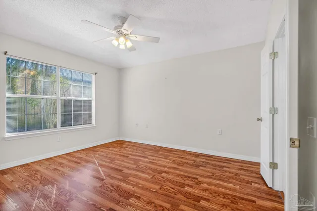 a view of a room with wooden floor and ceiling fan