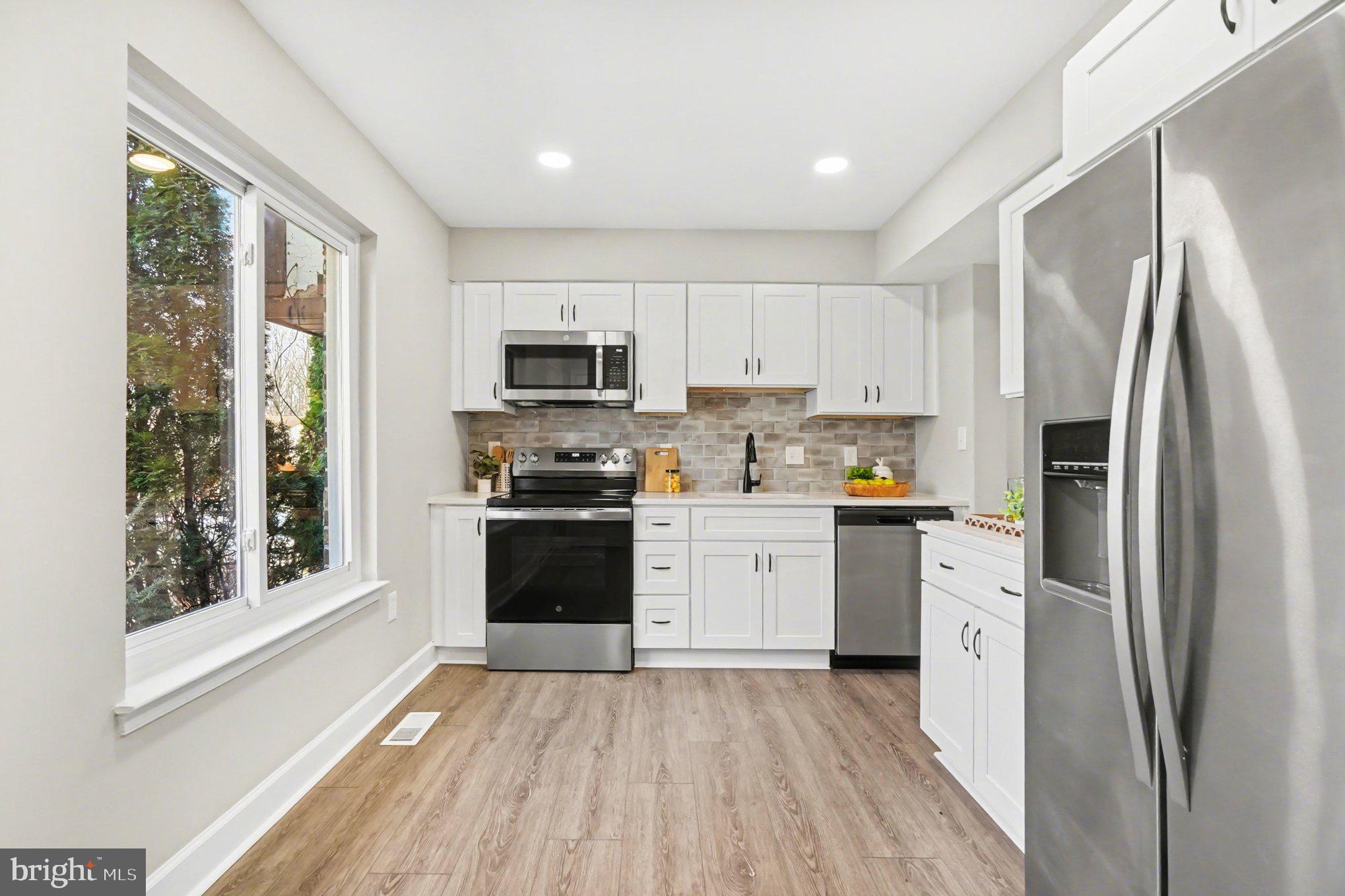 32 Romanoff Court Baltimore, MD 21234 - Photo 5 of 26 a kitchen with a refrigerator a stove top oven a sink and a window