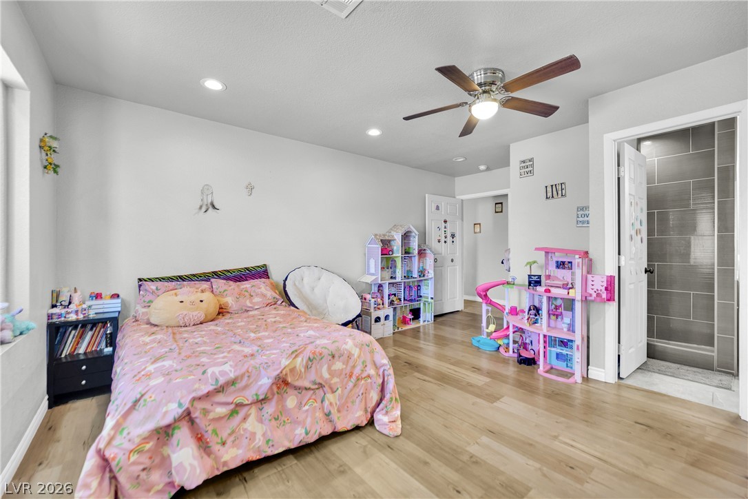 420 North Racetrack Road Henderson, NV 89015 - Photo 23 of 52 A comfortable bedroom features light wood flooring and a refreshing ceiling fan for year-round comfort.